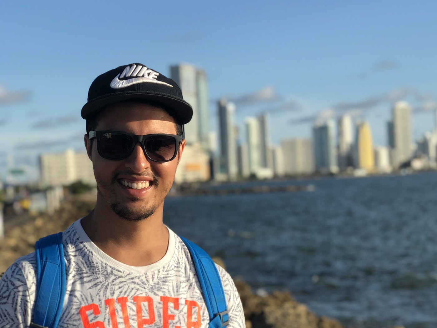 Nabil aan de kust, met pet en zonnebril